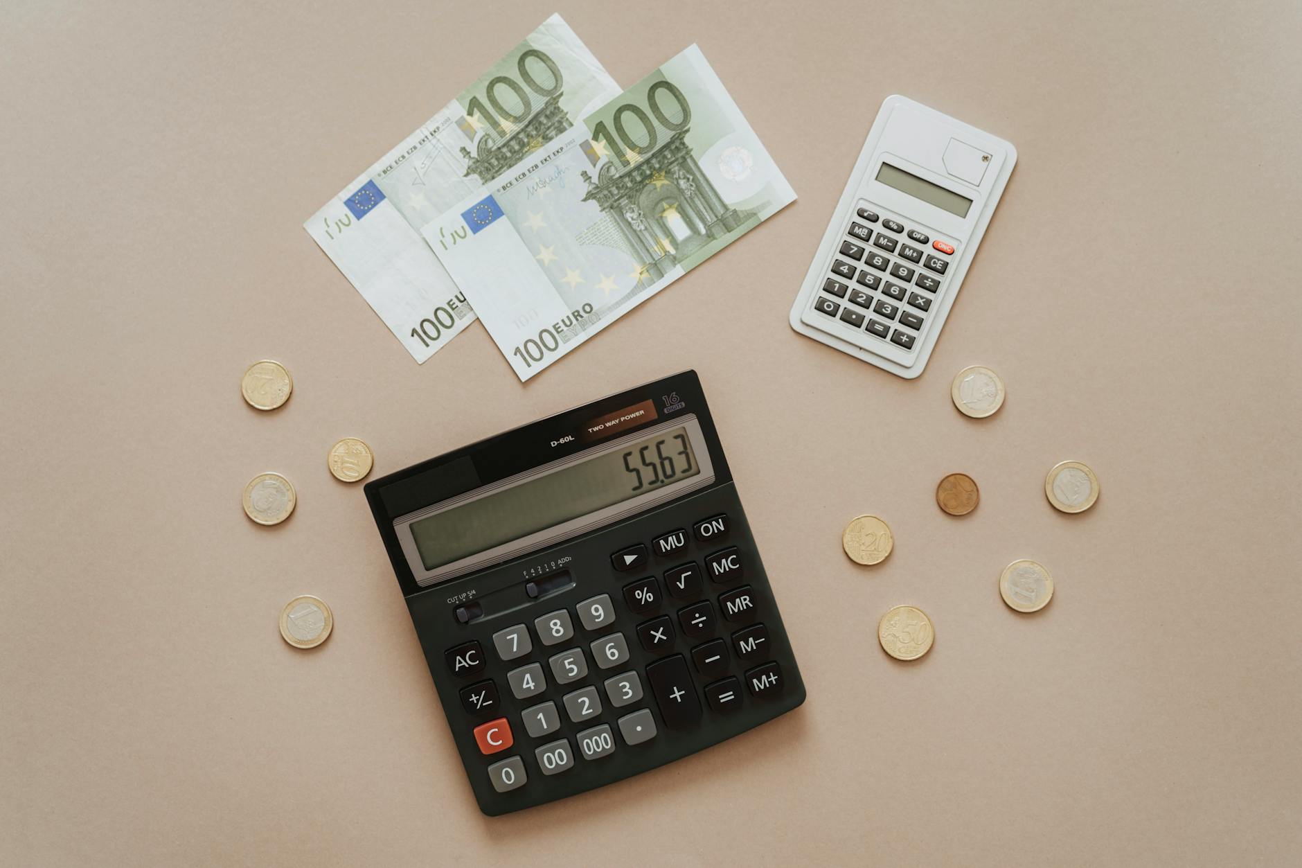 black and silver calculator beside silver coins